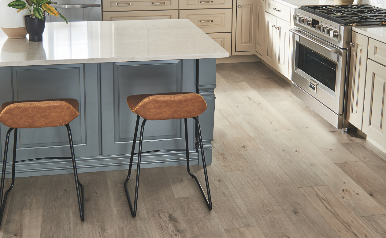 Laminate flooring in a kitchen with an island and two leather barstools