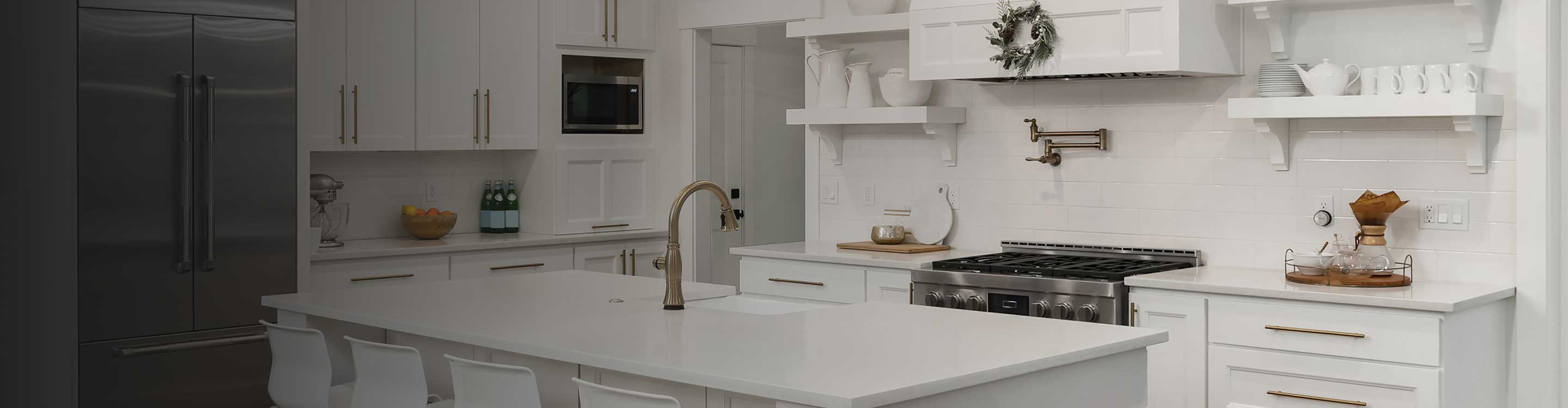 White kitchen with a large island, marble floors and white cabinetry